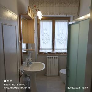 baño con lavabo y aseo y ventana en DESTINAZIONE PARADISO, en Piombino