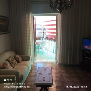 een woonkamer met een bank en een glazen schuifdeur bij DESTINAZIONE PARADISO in Piombino