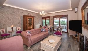Una sala de estar con un sofá y un televisor. en Ariadni Vista Mare Villa by "elite", en Lithakia