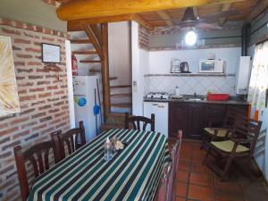 a dining room with a table and a kitchen at Cabañas Rincón del Río in Colón