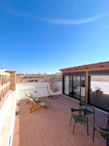 a deck with chairs and a bench on a roof at Arcos de Medina - Apartamentos premium in Córdoba