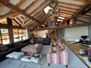 uma ampla sala de estar com um sofá e cadeiras em Chalet Violettes em Villaroger