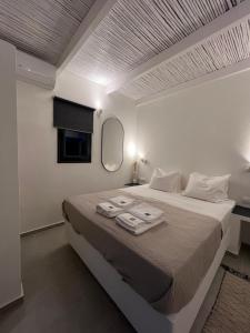 a white bedroom with a bed with towels on it at Vie rêvée luxury suites in Ganema