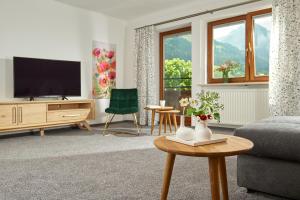 a living room with a couch and a tv at Gästehaus Hornblick in Oberstdorf