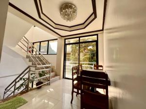 a dining room with a staircase and a table and chairs at Alocasia Hostel in El Nido