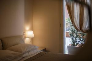 a bedroom with a bed and a window with a plant at Residence Millecento in Cesenatico