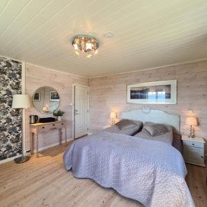 een slaapkamer met een bed, een tafel en een spiegel bij VILLA HASSELBAKKEN in Eidsvoll