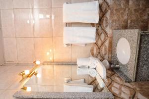 a bathroom with a toilet and a mirror and towels at South Gate Hotel Apartment in Addis Ababa