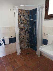 bagno con doccia, vasca e lavandino di LudoMar Country Residence - Rooms & Apartments a SantʼAndrea Apostolo dello Ionio