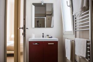 ein Bad mit einem Waschbecken und einem Spiegel in der Unterkunft Residence Millecento in Cesenatico