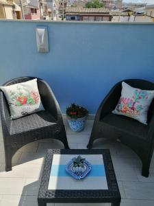 2 chaises en osier et une table sur la terrasse dans l'établissement Borgata Mazzarelli 2, à Marina di Ragusa