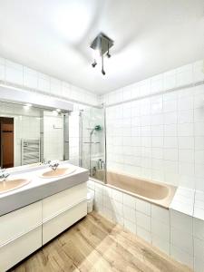 La salle de bains est pourvue de 2 lavabos et d'une baignoire. dans l'établissement T2 parking/climatisation - proche Halles au grain, à Toulouse
