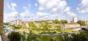 um rio numa cidade com uma ponte e edifícios em T2 parking/climatisation - proche Halles au grain em Toulouse