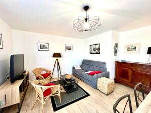 uma sala de estar com um sofá e uma televisão em T2 parking/climatisation - proche Halles au grain em Toulouse