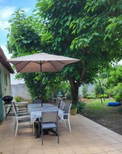 stół i krzesła z parasolem na patio w obiekcie Maison verdure & calme w mieście Castries