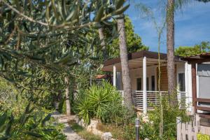 une maison avec des palmiers devant elle dans l'établissement Camping Stobreč Split, à Split