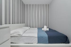 a bedroom with a bed with a blue and white blanket at Modern Studio with Balcony for 4 Guests in Wrocław by Renters in Wrocław