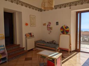 Zimmer mit einem Kinderzimmer mit einem Tisch und einem Fenster in der Unterkunft Il Casale la Lupa in Nunziata