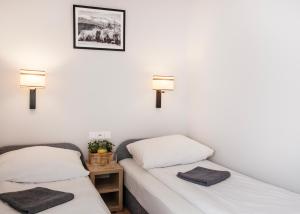 シュクラルスカ・ポレンバにあるWilla Izabelaのベッド2台 壁にランプ2つが備わる客室です。