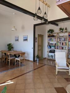 - un salon avec une table, des chaises et des étagères dans l'établissement Il Casale la Lupa, à Nunziata