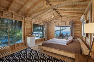 a log cabin bedroom with a bed and large windows at Flavia Hotel in Kızılcakaya