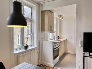 a kitchen with a black pendant light and a kitchen with a sink at Two Bedroom Apartment In Copenhagen, Woltersgade 9, in Copenhagen