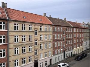 een groot bakstenen gebouw met auto's geparkeerd voor het bij Two Bedroom Apartment In Copenhagen, Woltersgade 9, in Kopenhagen