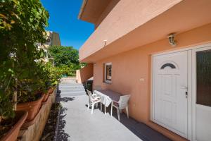 a patio with a table and chairs and a white door at House Harry near Supermarket and Center in Novalja