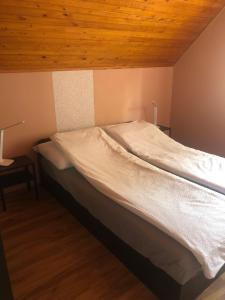 Bett in einem Zimmer mit Holzdecke in der Unterkunft Bonita Apartman in Balatonberény