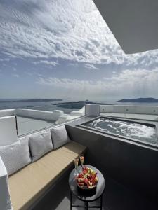 a balcony with a bench and a hot tub on a boat at Kafieris View in Firostefani
