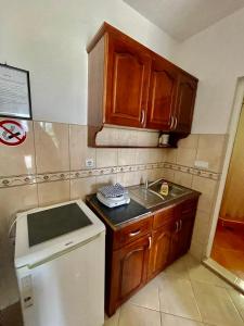 una pequeña cocina con armarios de madera y fregadero en Apartments Dusseldorf, en Ulcinj