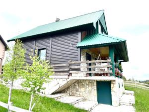 a small building with a green roof and stairs at Holiday Home Darko in Žabljak