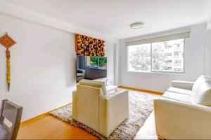 a living room with white furniture and a window at Green House in Lima