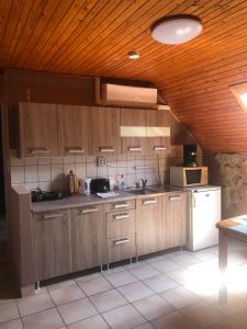 eine Küche mit Holzschränken und einem weißen Kühlschrank in der Unterkunft Bonita Apartman in Balatonberény