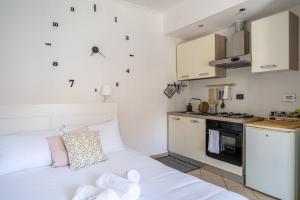 uma pequena cozinha com uma cama branca num quarto em Loft Verga, cuore e stile in centro a Torino em Turim