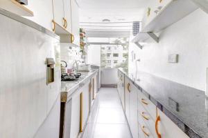 a kitchen with white walls and yellow cabinets at Green House in Lima