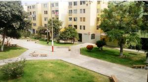 a park with benches in front of a building at Green House in Lima