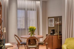 ein Wohnzimmer mit einem Tisch und einer Blumenvase darauf in der Unterkunft Electra Palace Thessaloniki in Thessaloniki