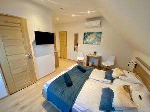 a large bedroom with a large bed and a television at GreenWood Vendégház in Siófok
