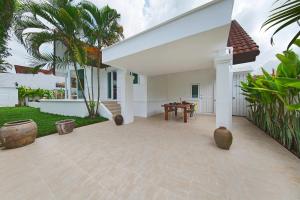 a patio of a house with a table and palm trees at Villa Lawana - Bophut - Stylish Private Luxury Villa in Bophut 