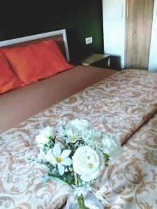un ramo de flores blancas sentado en una cama en F&M Apartment No 12, en Skopje