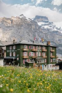 a building with american flags in front of a mountain at Hotel Drei Berge in Mürren