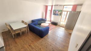 a living room with a blue couch and a table at 2 bedrooms appartement with wifi at Bruxelles in Bons Villers