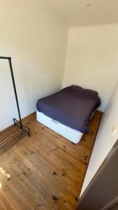 a bed in a small room with a wooden floor at 2 bedrooms appartement with wifi at Bruxelles in Bons Villers