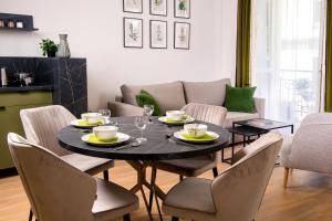 a dining room with a black table and chairs at Rajska Residence in Krakow