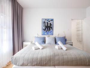 Tyzenhauz Villas في كراكوف: غرفة نوم بسرير كبير مع وسائد زرقاء