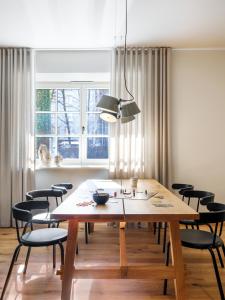 een eetkamer met een houten tafel en stoelen bij Tyzenhauz Villas in Krakau