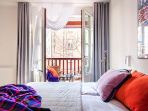 a bedroom with a bed and a balcony at Tyzenhauz Villas in Krakow