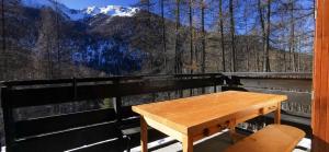 a wooden table on a balcony with a view of a mountain at Studio 4/5 personnes au pied des pistes Les Orres in Les Orres