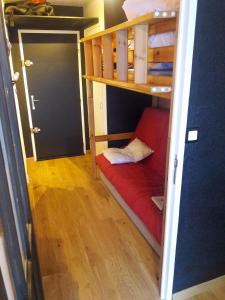 a small room with a red couch in a bunk bed at Studio 4/5 personnes au pied des pistes Les Orres in Les Orres